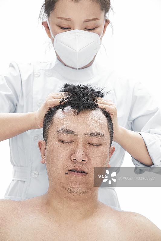 专业按摩师为男子进行身体按摩图片素材