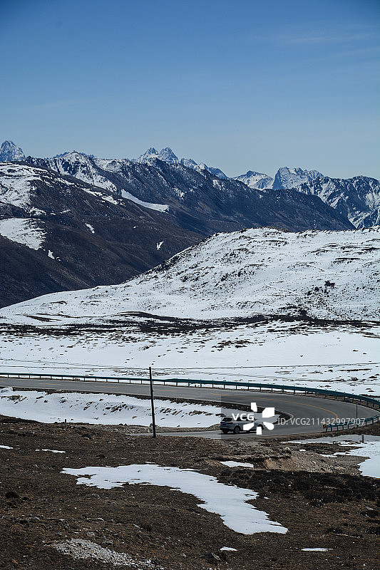 蓝天白云雪山下的曲折公路图片素材