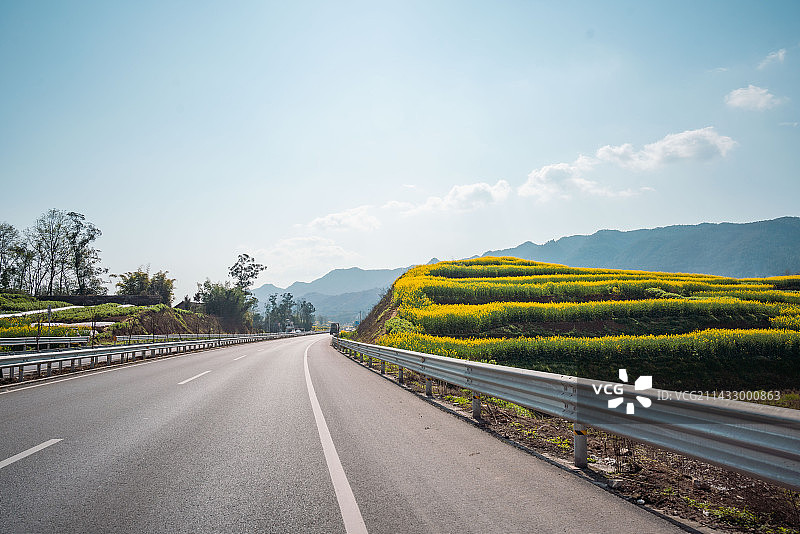 重庆垫江沙坪蓝天白云下的油菜花公路图片素材