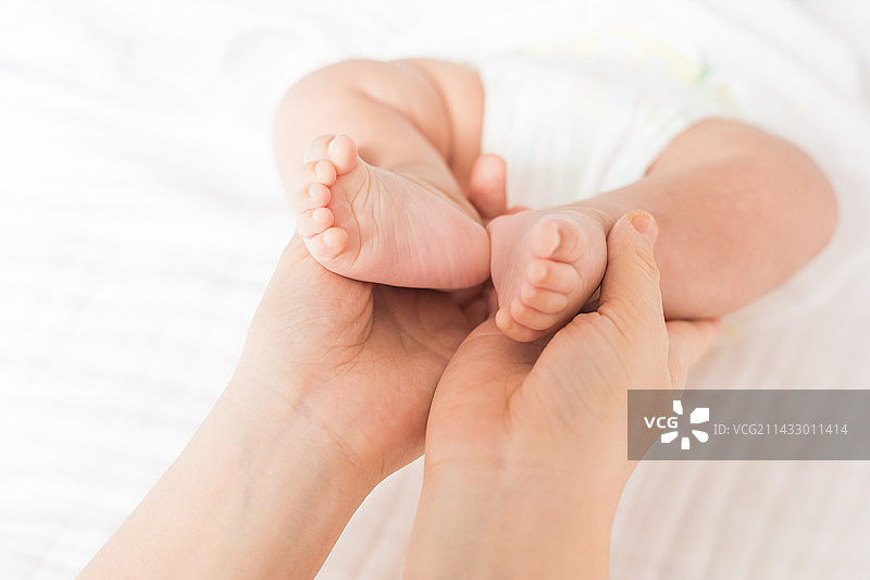 妈妈用手托住婴儿的小脚丫图片素材
