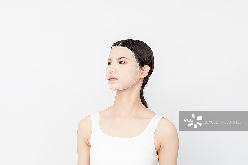 白色背景中一个敷面膜的亚洲美女图片素材