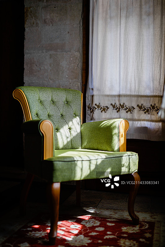 阳光光影下的绿色设计感古董沙发椅图片素材