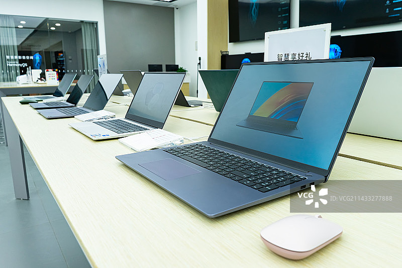 中国电子产品拍摄主题，专卖店的桌子上摆放着成一排的笔记本电脑，室内无人图像摄影图片素材