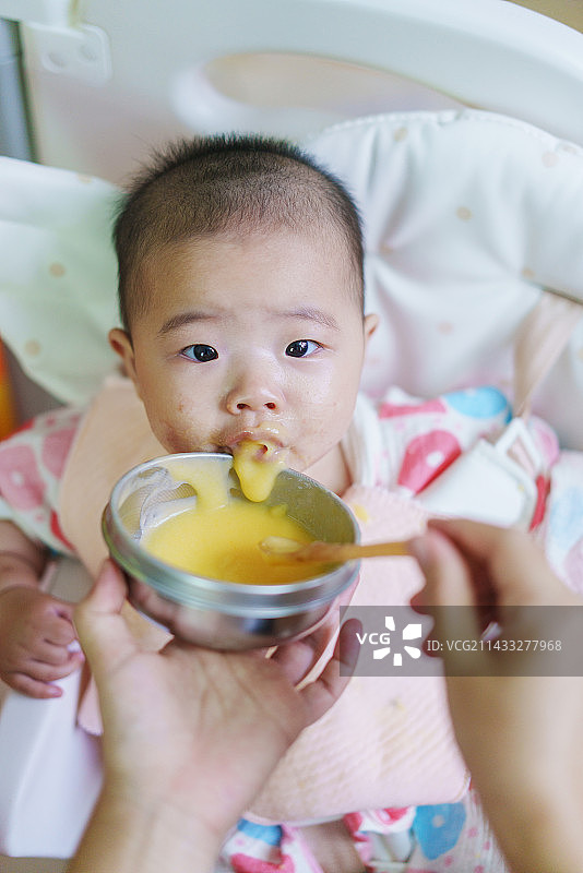 正在吃辅食的六月龄女宝宝图片素材