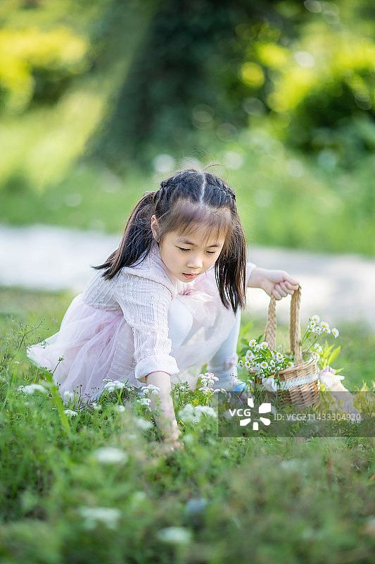 提着小花篮在公园里玩耍的小女孩图片素材