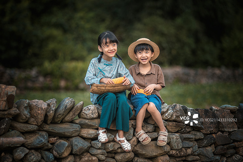 姐弟俩开心的坐在围墙上图片素材