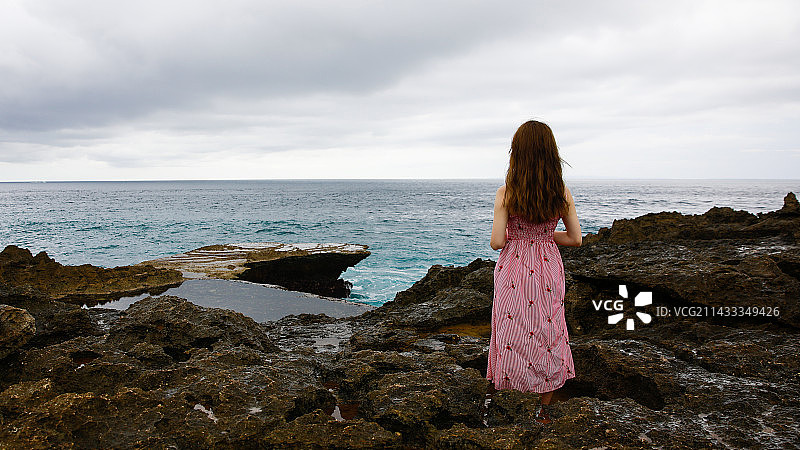 恶魔的眼泪海岸线眺望远处的女孩的背影图片素材