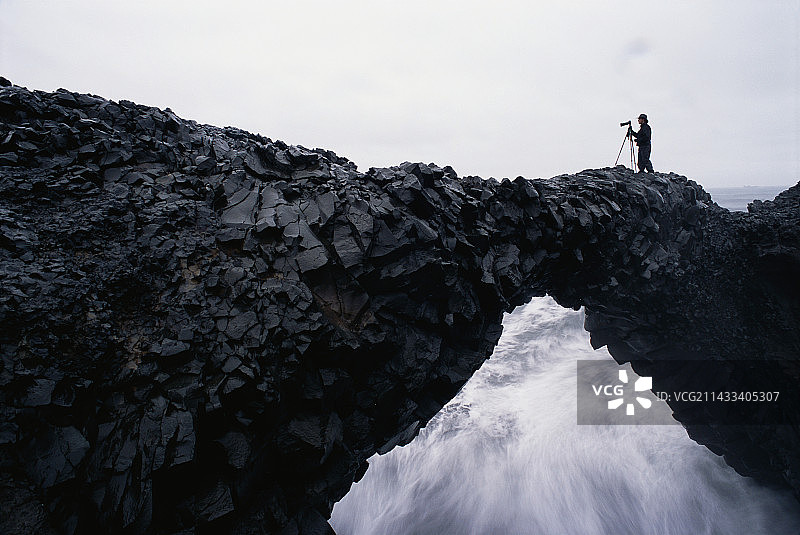 在冰岛天然拱顶上的摄影师图片素材
