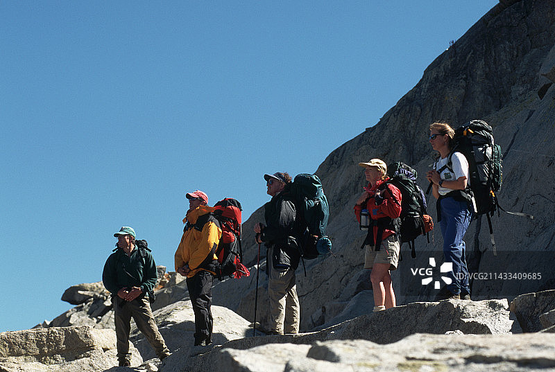 站在花岗岩悬崖上的背包客图片素材
