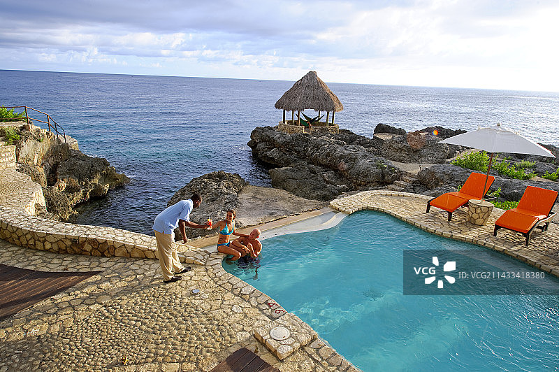 牙买加蒙特哥贝，情侣在泳池边畅饮图片素材