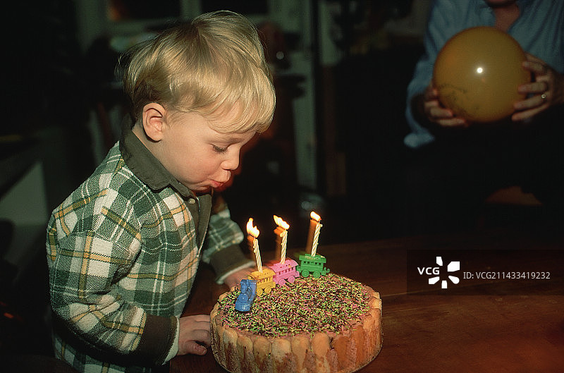 男孩吹灭生日蜡烛图片素材