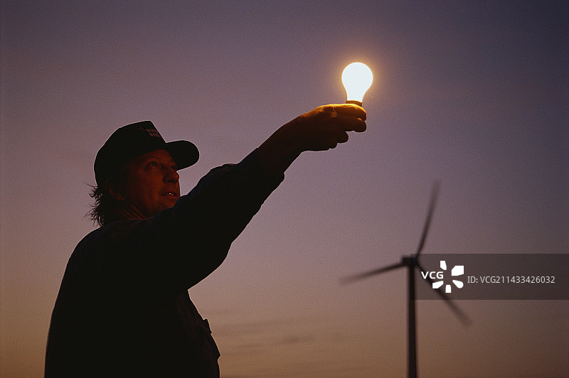 手持发光灯泡的男人图片素材