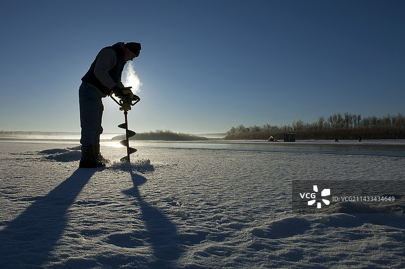 在密苏里河冰面上钻冰洞的渔民图片素材