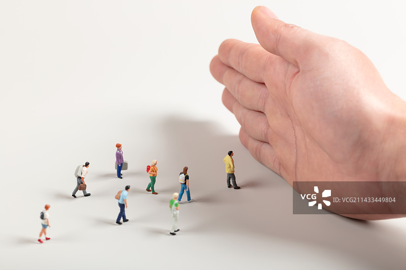 微缩创意用手揽住人群的去路图片素材