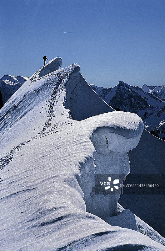 登山者攀登雪檐，非常险峻图片素材