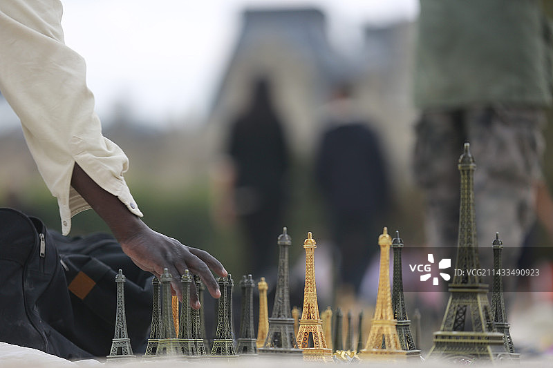 在巴黎杜乐丽花园出售埃菲尔铁塔雕像的男人图片素材