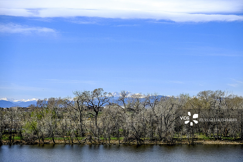 蓝天下河流边树林远处雪山图片素材