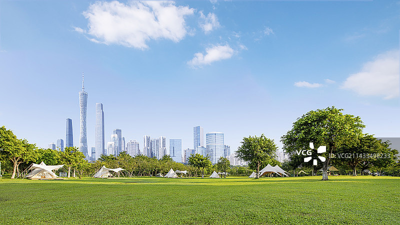 蓝天白云下的广州城市建筑和公园露营草地图片素材