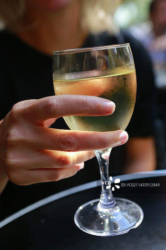 女人在巴黎拿着一杯白葡萄酒图片素材