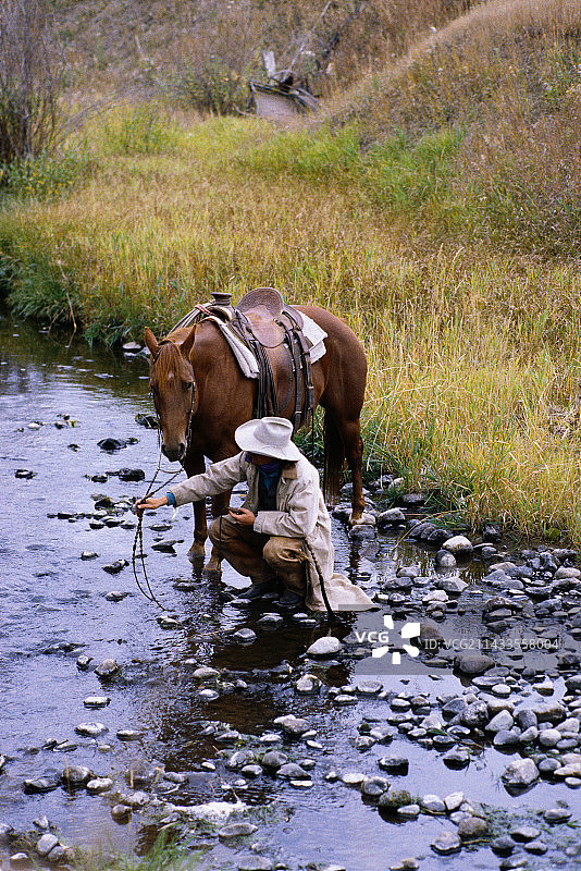 牛仔带马去取水图片素材