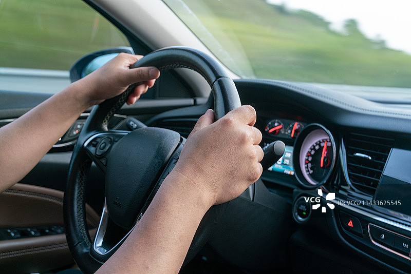 行驶中的轿车内男性司机开车手握着方向盘图片素材