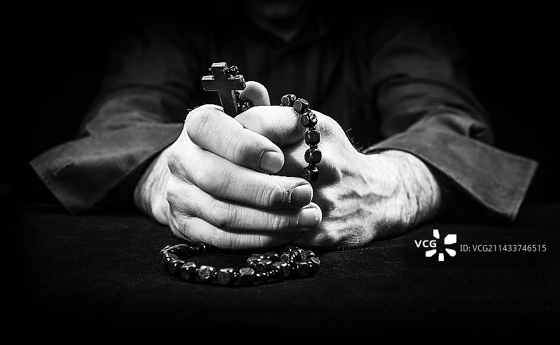 手持念珠和十字架祈祷图片素材