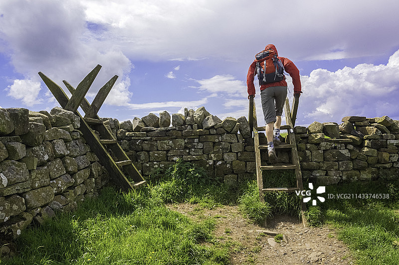 徒步者穿越斯泰尔栅栏 - 哈德良长城步道图片素材