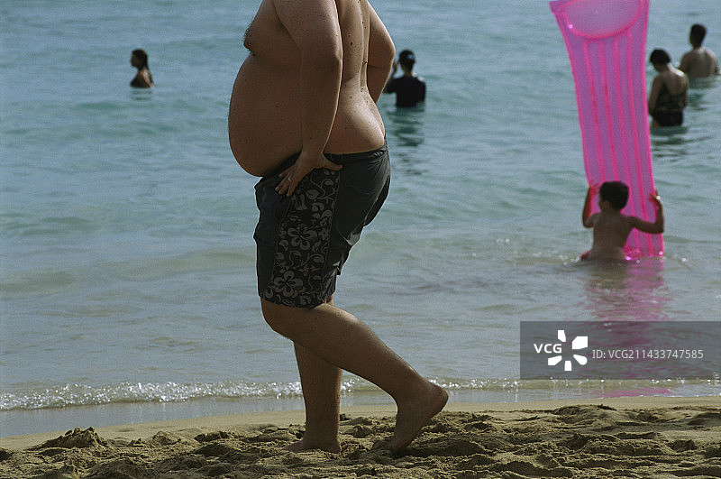 在海滩上的肥胖男人图片素材