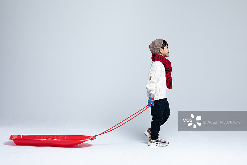儿童雪橇，冬季，男孩拖着雪橇行走图片素材