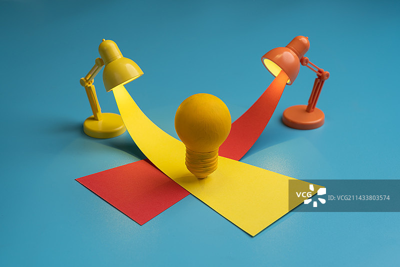 黄色的灯泡放在红色两色的台灯射出的光交织处微缩创意图片素材