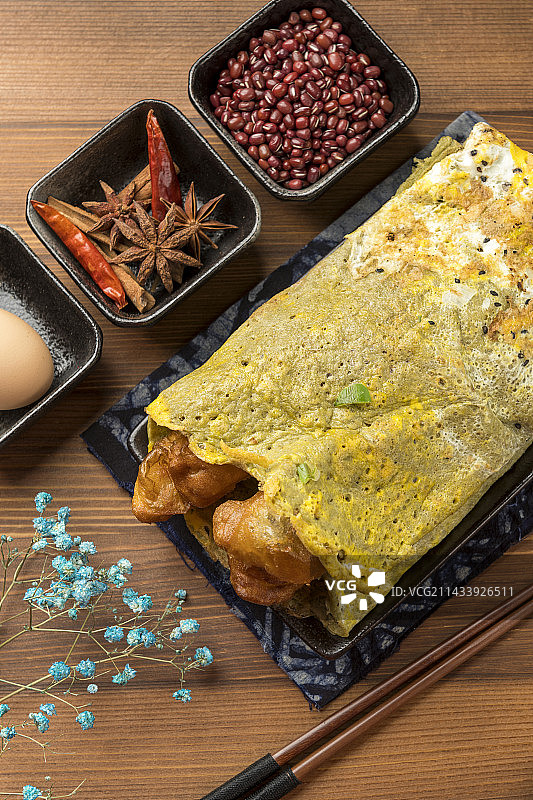 天津特写小吃煎饼果子摆放在木桌面上图片素材