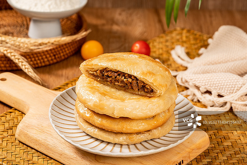 木板背景上一盘美味的牛肉饼图片素材