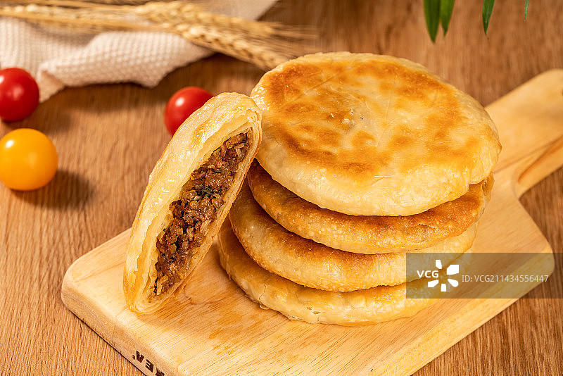 木板背景上一盘美味的牛肉饼图片素材