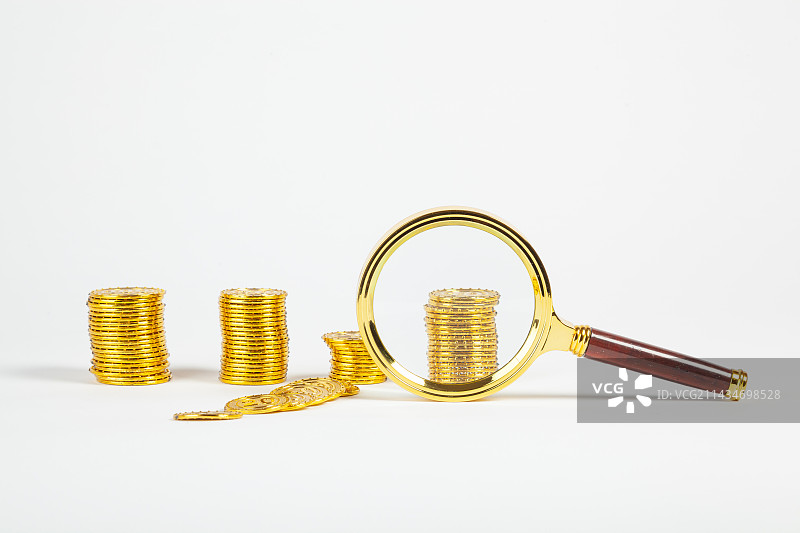 白色背景上的金币，放大镜，GDP标语图片素材