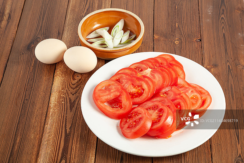 木桌子上的切好的西红柿，葱花，鸡蛋图片素材