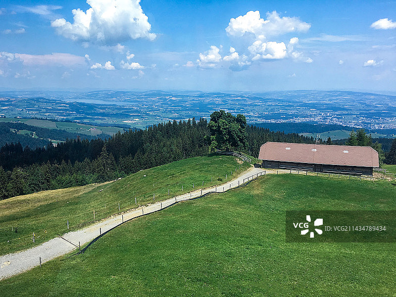 蓝天白云下的瑞士高山田野草坪农舍图片素材