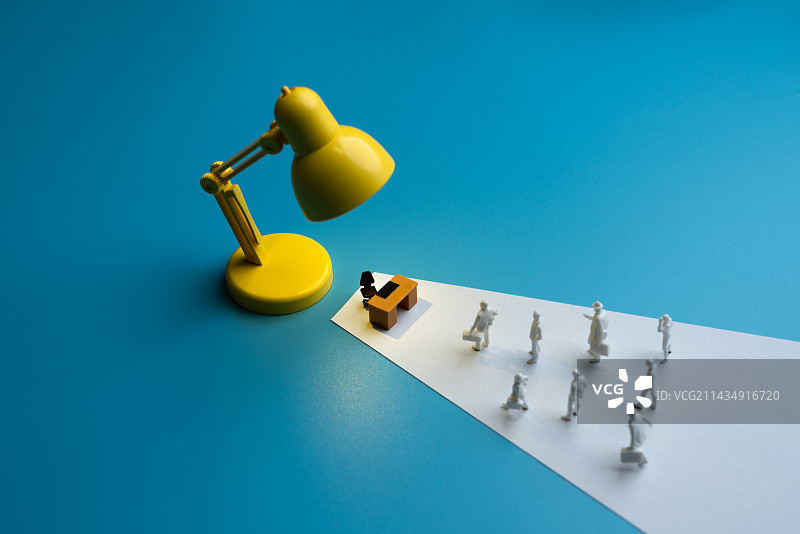 黄色台灯下的办工作和求职的人群微缩创意图图片素材