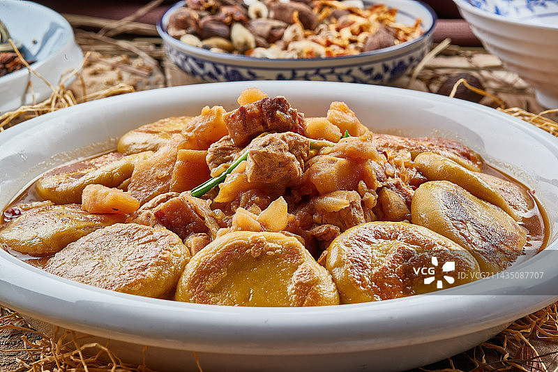 圆瓷盘装的农家炖菜配拿糕图片素材