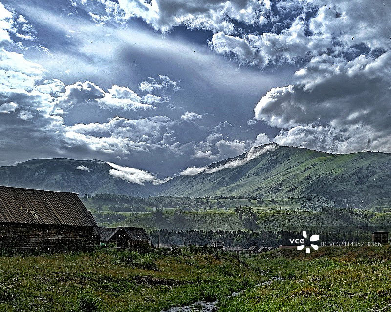 夏季新疆风光-云下山谷和村庄图片素材