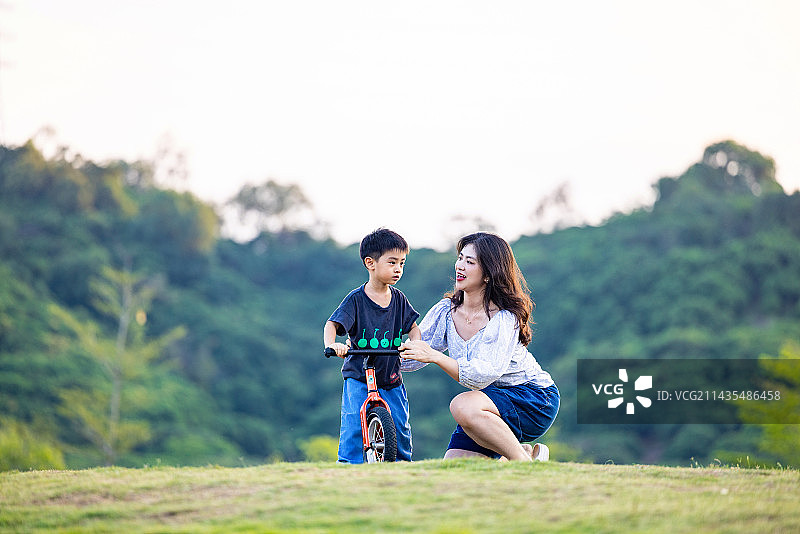 一位母亲带着儿子在玩平衡车图片素材
