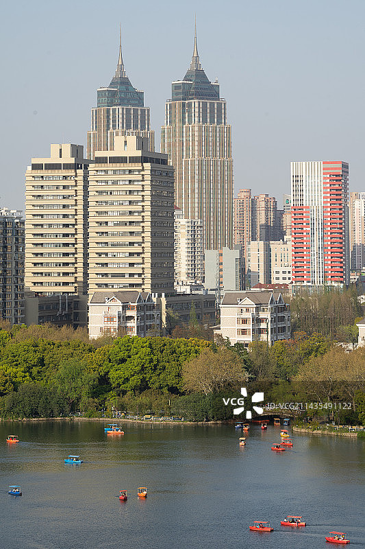 城市建筑群中的城市公园和湖面游船图片素材