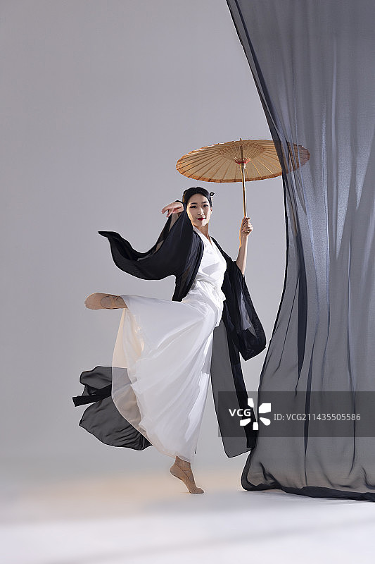 中国水墨油纸伞古典舞：古装美女舞者、油纸伞与黑色薄纱图片素材