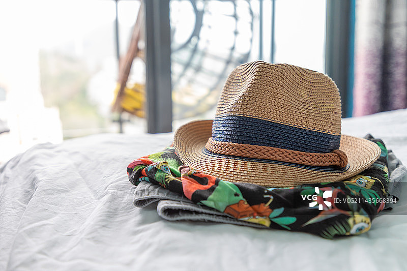 草帽和衣服在床上图片素材