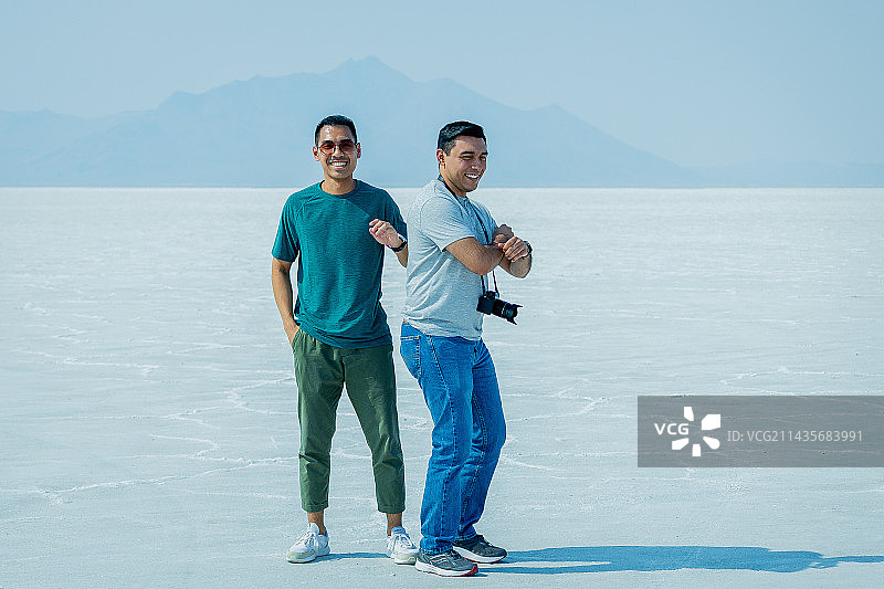 站在白色沙滩上的年轻男子肖像，背景为晴朗的天空，博纳维尔盐滩，犹他州，美国图片素材