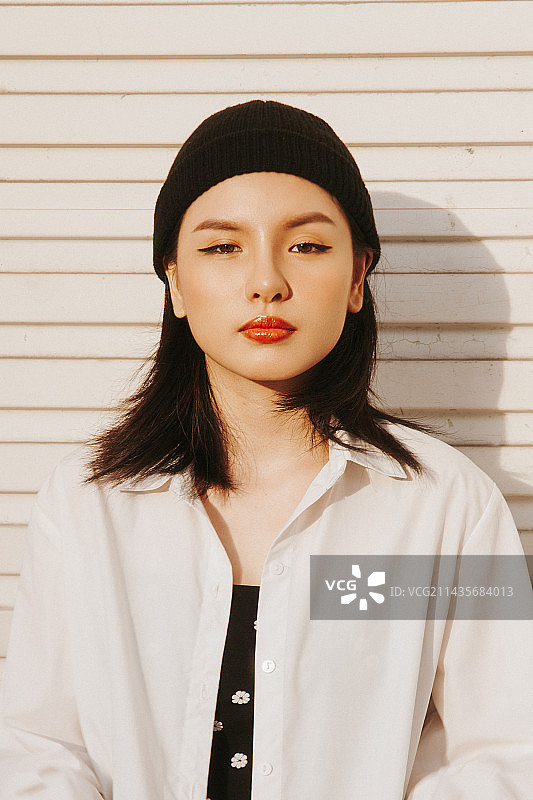 靠墙站立的美丽年轻女人 портрет图片素材