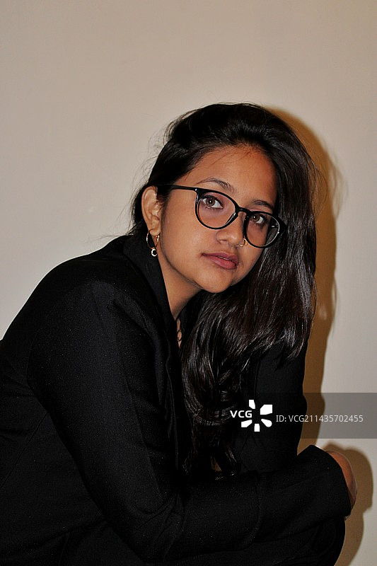 年轻女子靠墙而坐图片素材