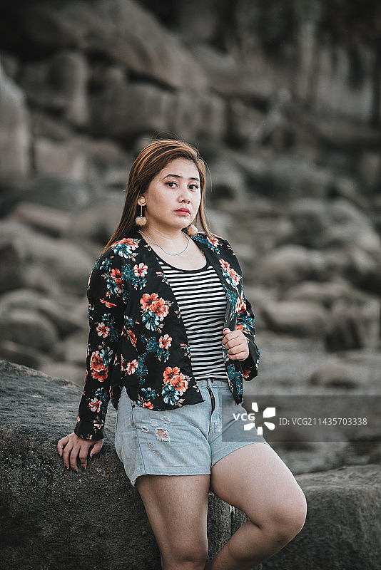 站在岩石上的年轻女子肖像图片素材