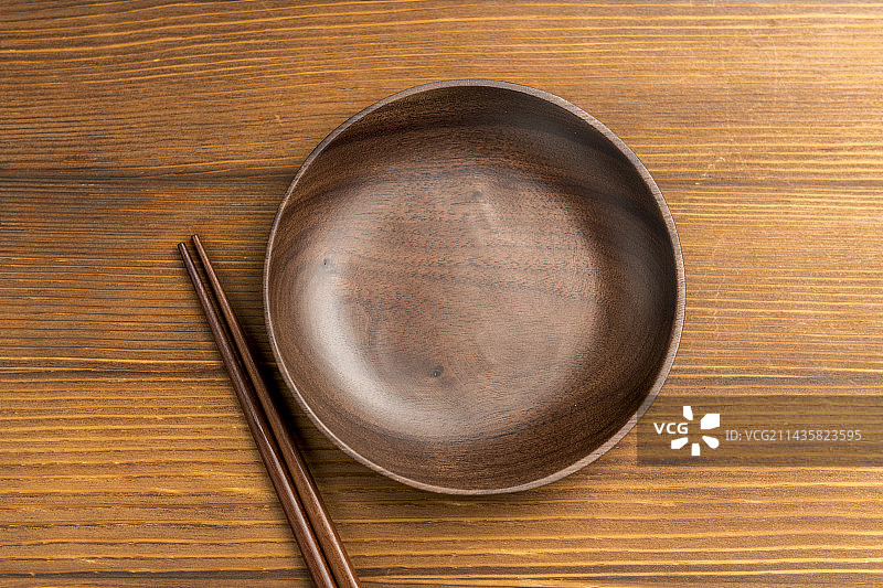 黑胡桃圆形木碟摆放在木桌面上特写图片素材