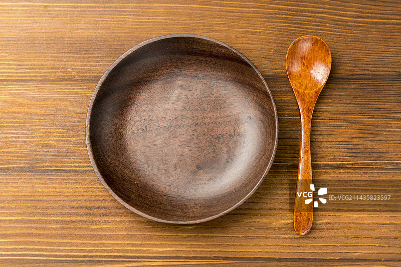 黑胡桃圆形木碟摆放在木桌面上特写图片素材