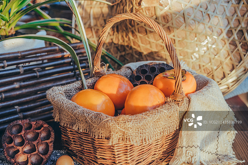 金黄饱满的柿子果摆放在果篮中图片素材